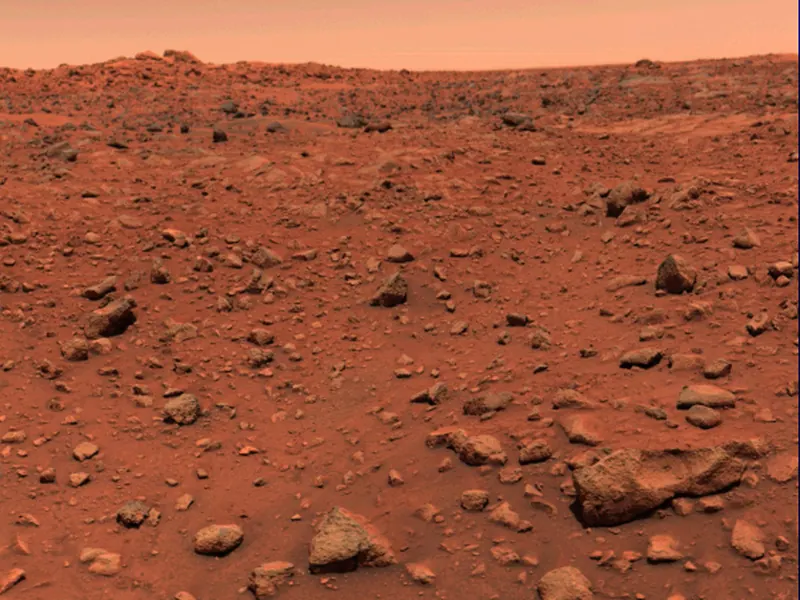 A rocky, orange-red Martian landscape under a pale sky